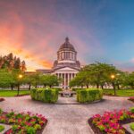 The capitol building in Olympia at sunset with gardens surrounding it.