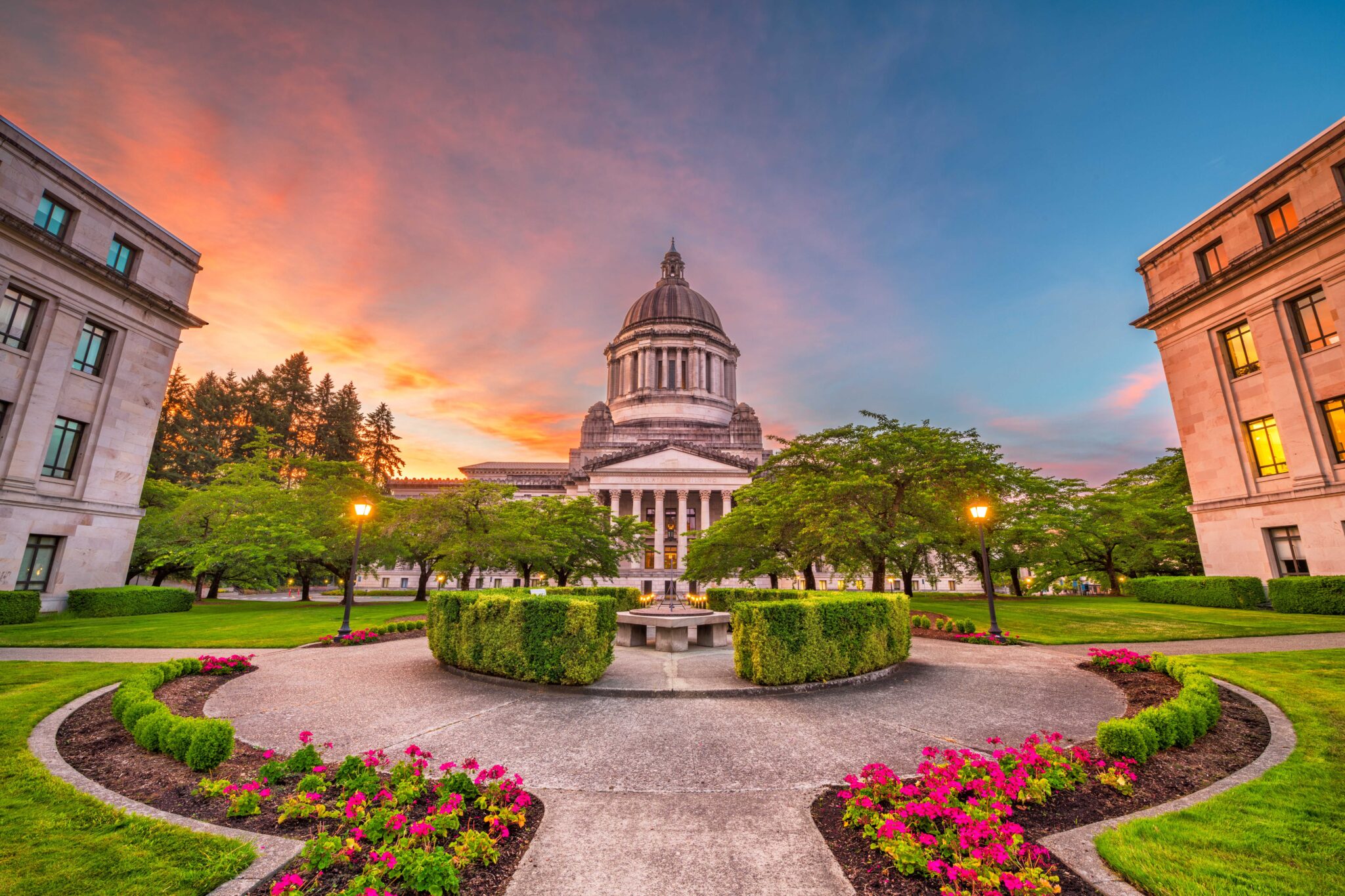 The capitol building in Olympia at sunset with gardens surrounding it.